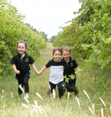 kids running through vineyard